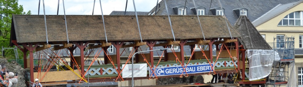 Ein Schwerlastkran hebt das Römertor zurück an seinen angestammten Platz