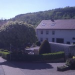 Ein Bauernhaus, davor ein Brunnen.